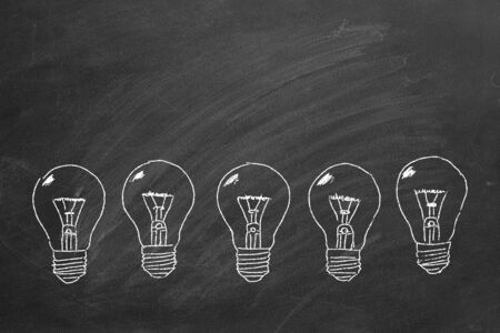 Row of light bulbs chalk drawing on  blackboard.の写真素材