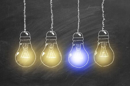 Row of light bulbs chalk drawing on  blackboard. Unique thinking concept