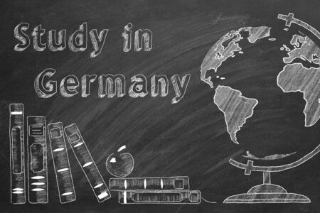 Lettering "Study in Germany", globe and school books are drawn with chalk on a blackboard. Study abroad concept.の写真素材