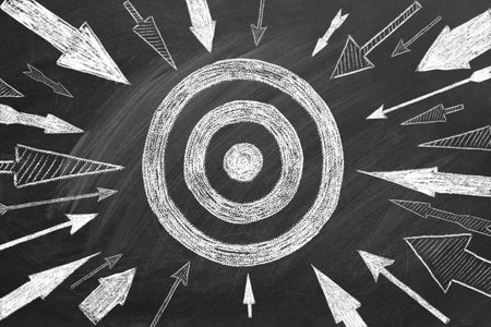 Many different arrows and target drawn in chalk on a blackboard. Concept of competition, strategy, accuracy.の写真素材