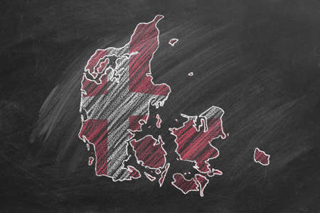 Country map and flag of Denmark drawing with chalk on a blackboard. One of a large series of maps and flags of different countries. Education, travel, study abroad concept.の写真素材