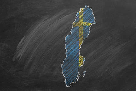 Country map and flag of Sweden drawing with chalk on a blackboard. One of a large series of maps and...