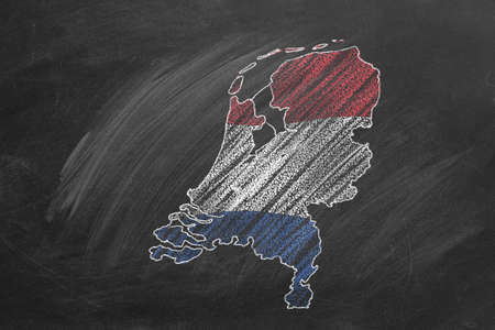 Country map and flag of The Netherlands drawing with chalk on blackboard. Hand drawn animation. One of a large series of maps and flags of different countries. Education, travel, study abroad conceptの写真素材