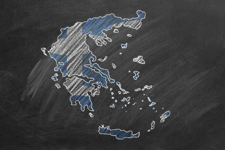 Country map and flag of Greece drawing with chalk on a blackboard. One of a large series of maps and flags of different countries. Education, travel, study abroad concept.の写真素材