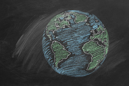 The globe hand drawn in chalk on a school blackboard.の写真素材