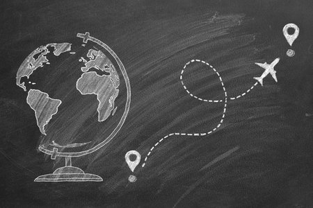 Time to travel. A chalk drawn illustration of a world globe on a blackboard, and airplane following...