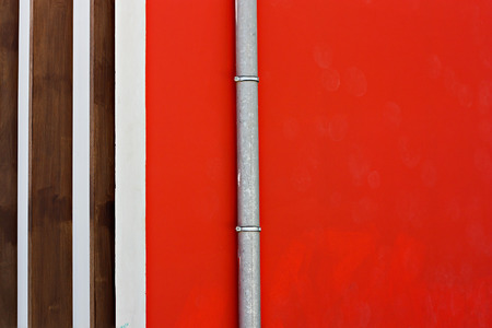 Red wall with pipe fragment close upの写真素材