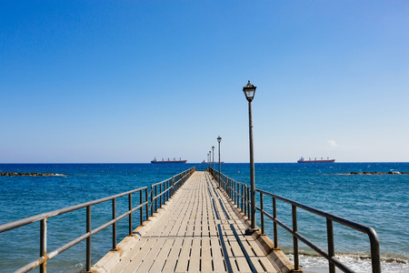 Old wooden pier over the Mediterranean sea shore in bright summer day. Limassol, Cyprus.の写真素材