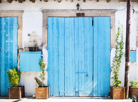 Closed big old blue door with plants at the street. Mediterranean style.の写真素材