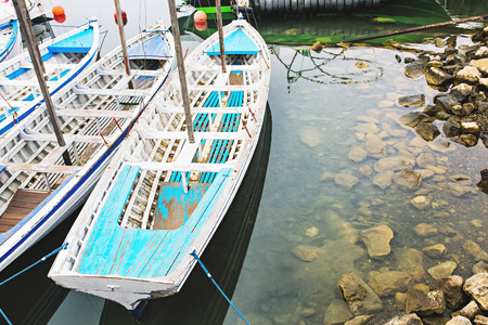 A few blue fishing boats tied up to a pier.の写真素材
