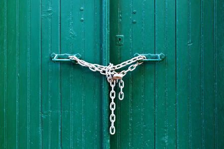 Locked wooden green teal door with chain
