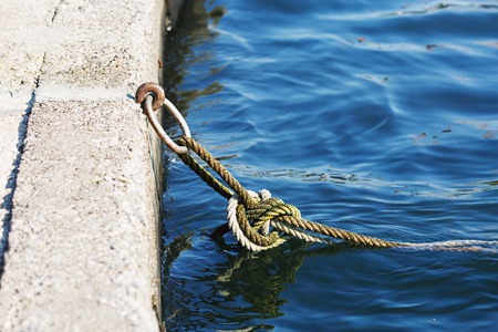 Mooring knot with rings, rope and green algaeの写真素材
