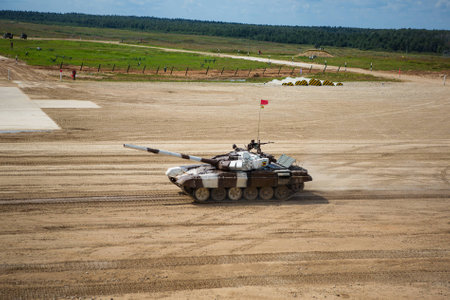 Military or army tank ready to attack and moving over a deserted battle field terrainの写真素材