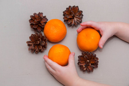 Mandarins and bumps in the hands of a child Christmas compositionの写真素材