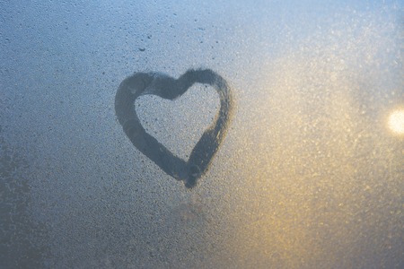 Figure of the heart on a frozen window in the cityの写真素材