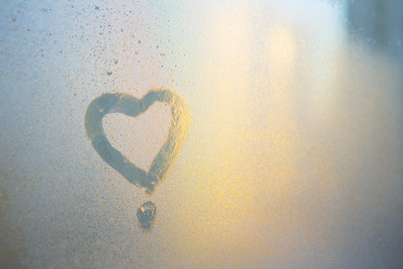 Figure of the heart on a frozen window in the cityの写真素材