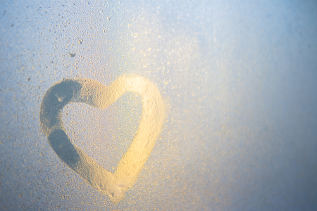 Figure of the heart on a frozen window in the cityの写真素材
