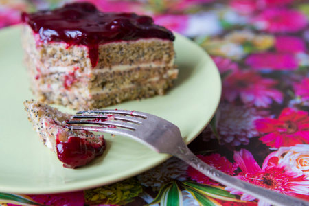 A piece of poppy cherry cake with a fork on a green plate. Healthy diet and diet. Compliance with diet.の写真素材