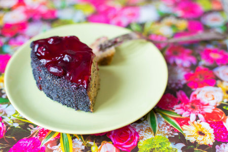 A piece of poppy cherry cake with a fork on a green plate. Healthy diet and diet. Compliance with diet.の写真素材