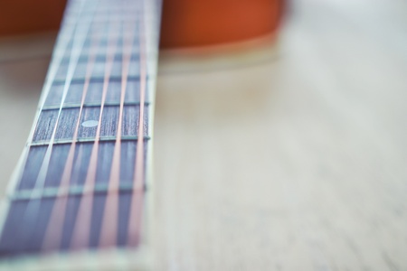 Vintage photo of acoustic guitar strings on wooden table, close up top view and sunlight with empty...
