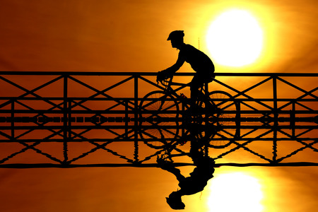 silhouette of a cyclist at sunsetの写真素材