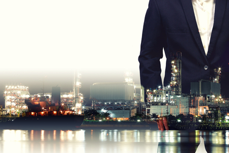 Double exposure of  businessman and  the oil refinery in the background .の写真素材