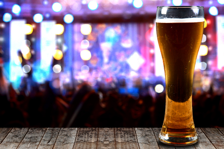 Glass of beer on a wooden background concert lights bokeh.Concept Festive Celebrations.の写真素材