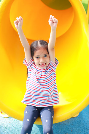 Little kid girl asian  while enjoying on the playground. Which increases the development and...