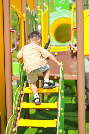 Little kid girl asian  while enjoying on the playground. Which increases the development and enhances outside the classroom learning skills concept.の写真素材