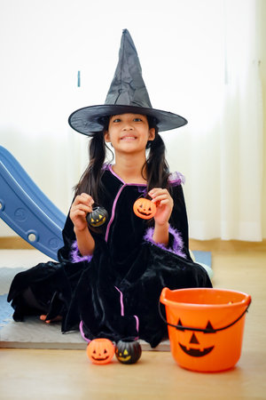 Halloween, holiday and childhood concept. Little kids southeast asian on halloween dressed in a witch costume.の写真素材