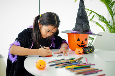 Halloween, holiday and childhood concept. Little kids southeast asian on halloween dressed in a witch costume.の写真素材