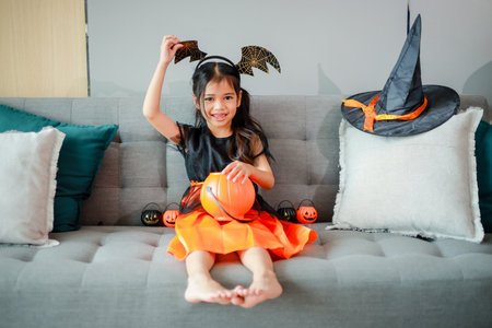 Halloween, holiday and childhood concept. Little kids southeast asian on halloween dressed in a witch costume.の写真素材