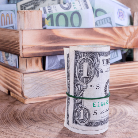 Dollar roll and wooden money crateの写真素材