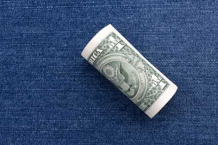 Dollar paper currency on denim jeansの写真素材
