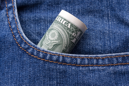 One Dollar paper currency roll in denim jeans pocketの写真素材