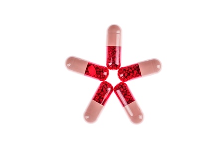 Star shaped pink and red pills, on whtie backgroundの写真素材