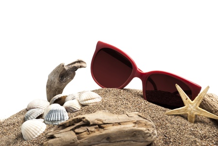 Sunglasses starfish seashells and wood pieces on the sandの写真素材