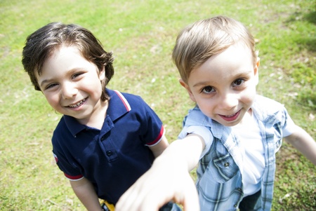 Two boys smiling and reaching the camera