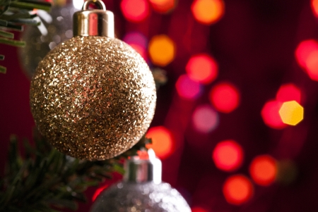 Christmas bauble hanging on pine tree with illuminated backgroundの写真素材