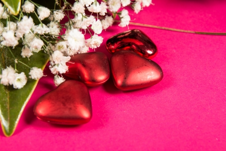 white flowers and red hearts isolated on the pink の写真素材