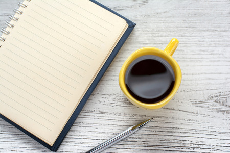 blank notebook coffee cup and notebook on wooden backgroundの写真素材