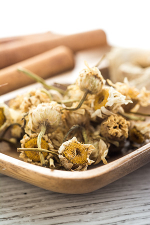Dried chamomile and ginger in bamboo platesの写真素材
