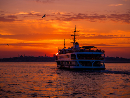 steamboat in Istanbul with seagulls at golden sunsetの写真素材