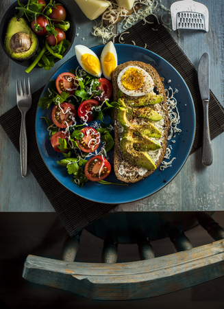 top view breakfast plate with avocado, egg, tomato and slice of breadの写真素材