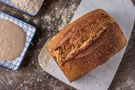 Artisan fresh sourdough bread on wooden table background