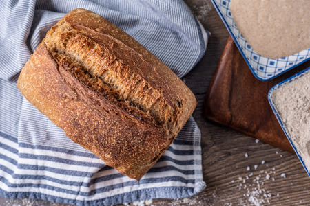 Artisan fresh sourdough bread on wooden table background