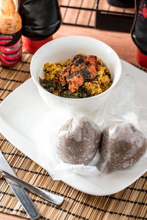 Regional African Food on white plate on wooden backgroundの写真素材