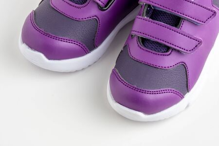 Pair of purple leather sport shoes for girls on white backgroundの写真素材