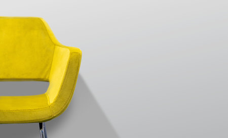 Yellow chair in front of a gray wall. Selective focus.の写真素材