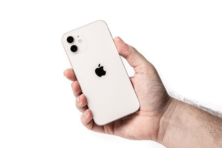 Antalya, Turkey - December 23, 2020: New design iPhone 12 in the white color in the hand of a...